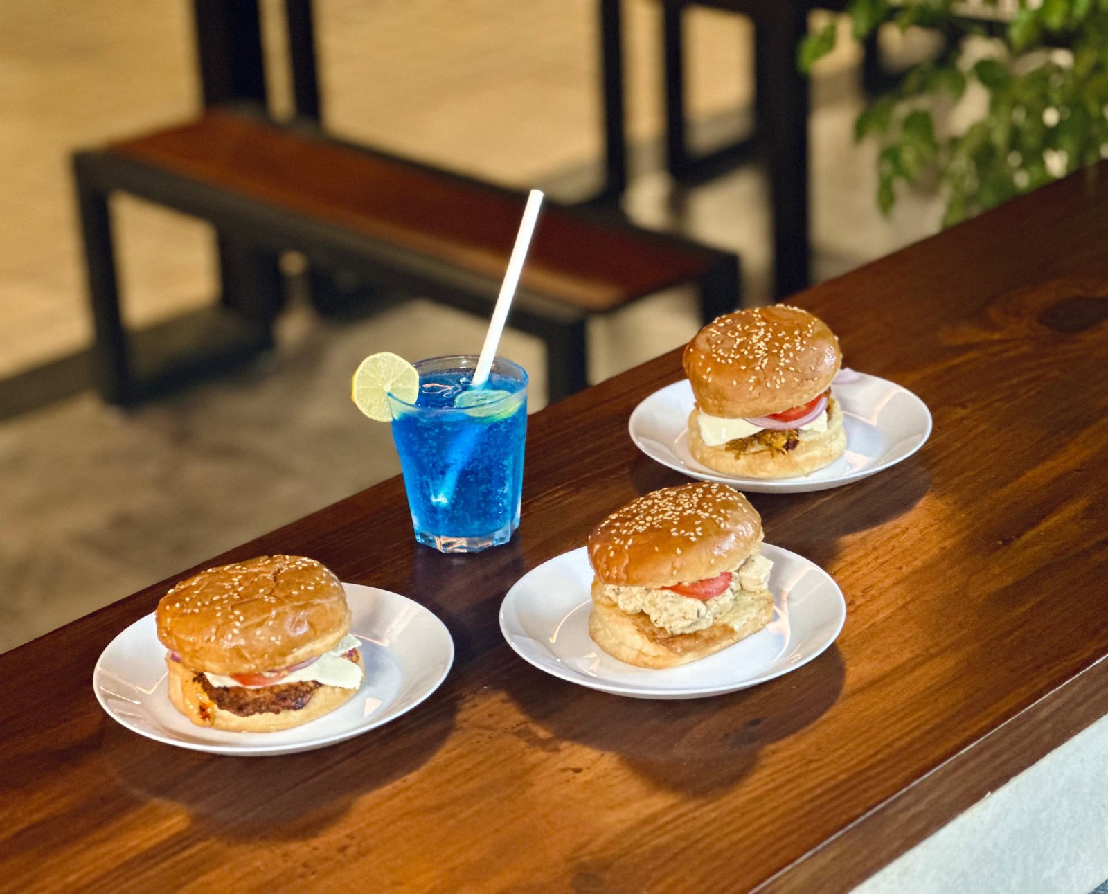 Burgers and blue mocktail on wooden table